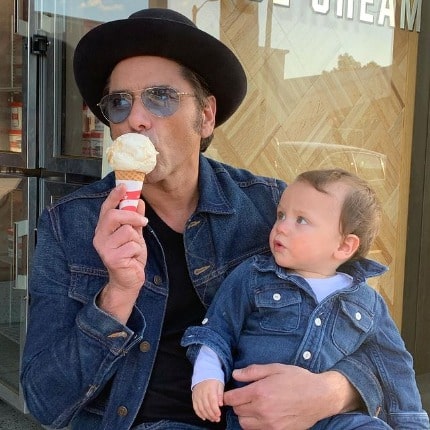 William wearing blue jeans and black hat and his son, Billy also wearing blue jeans.
